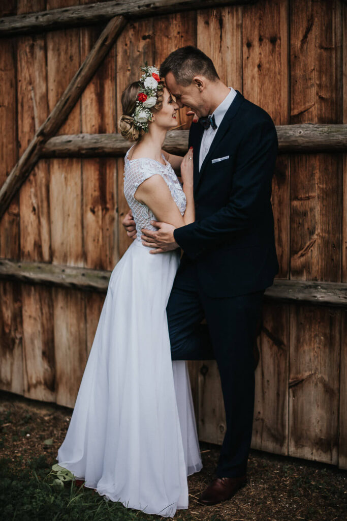 Rustykalna para młoda przytula się na tle bramy stodoły