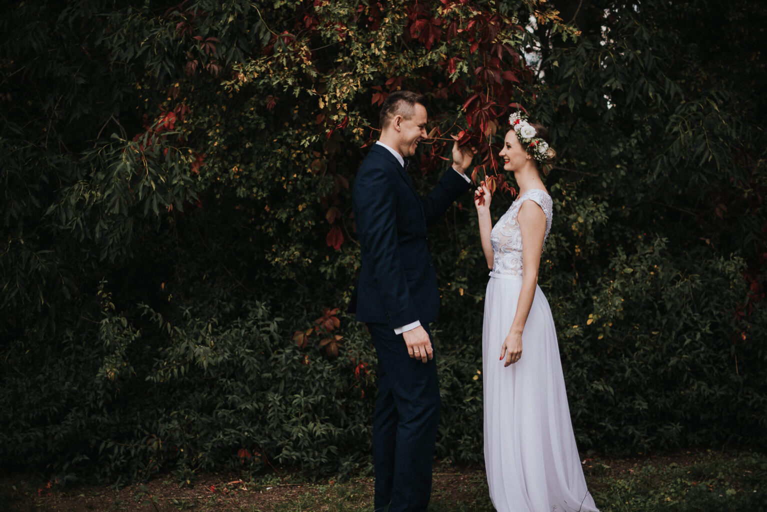 Para młoda pozuje na tle jesiennych drzew w Muzeum Wsi Opolskiej