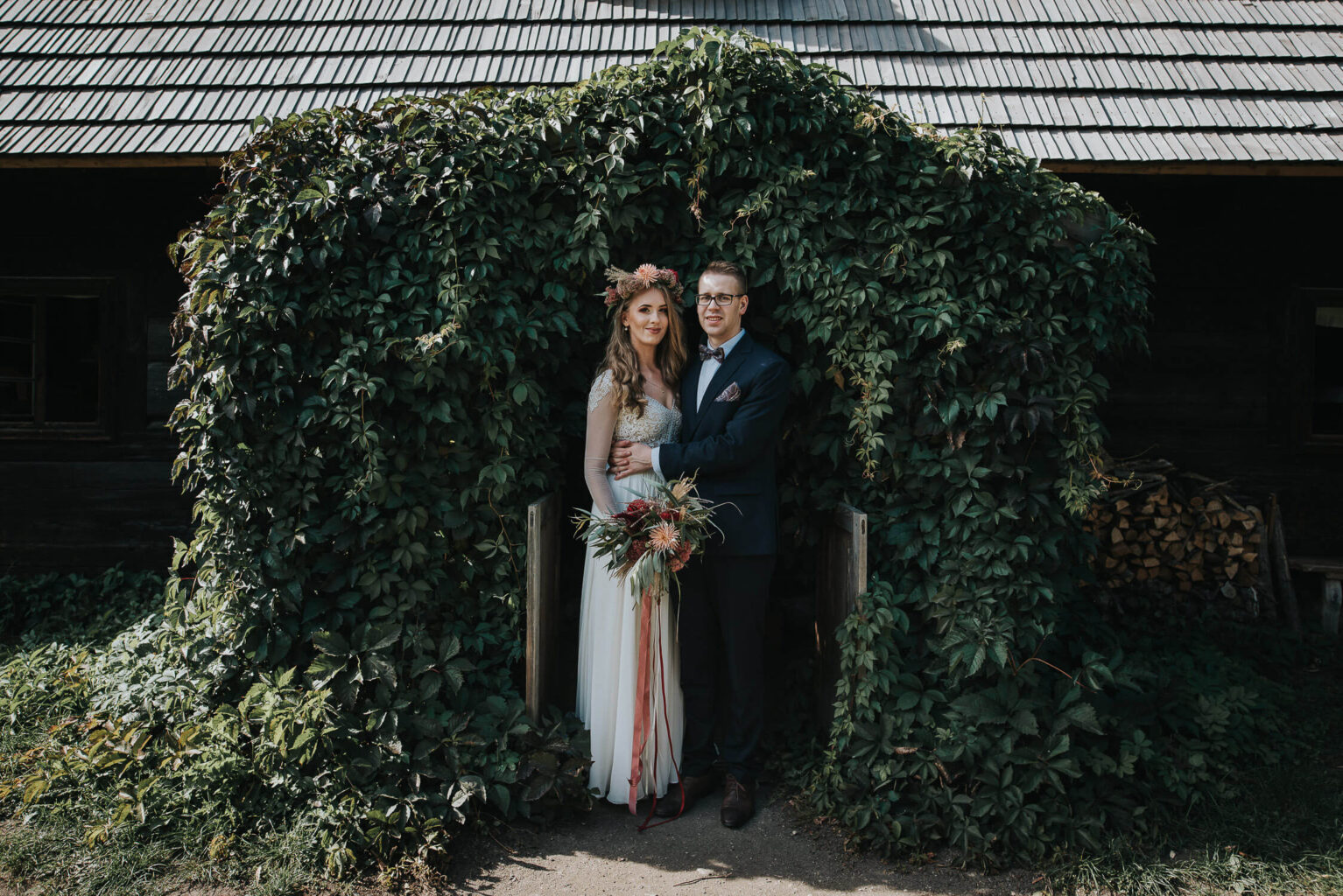 Para młoda pozuje na tle chatki w skansenie w Opolu