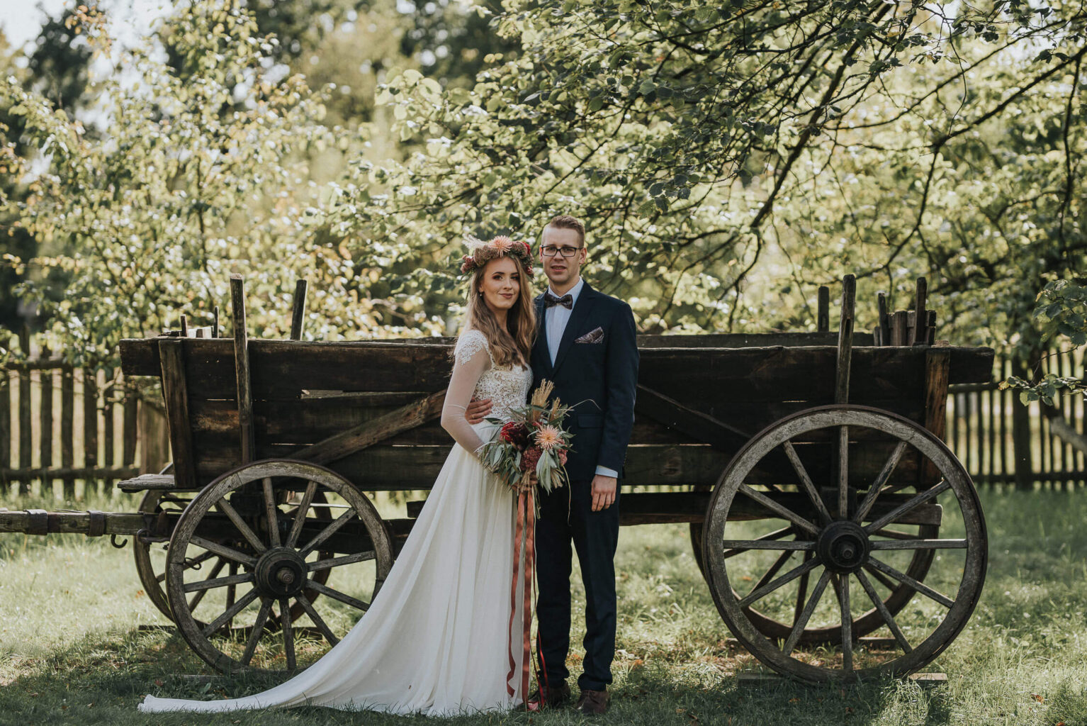 Pozująca do zdjęć para młoda podczas pleneru ślubnego wykonanego w skansenie