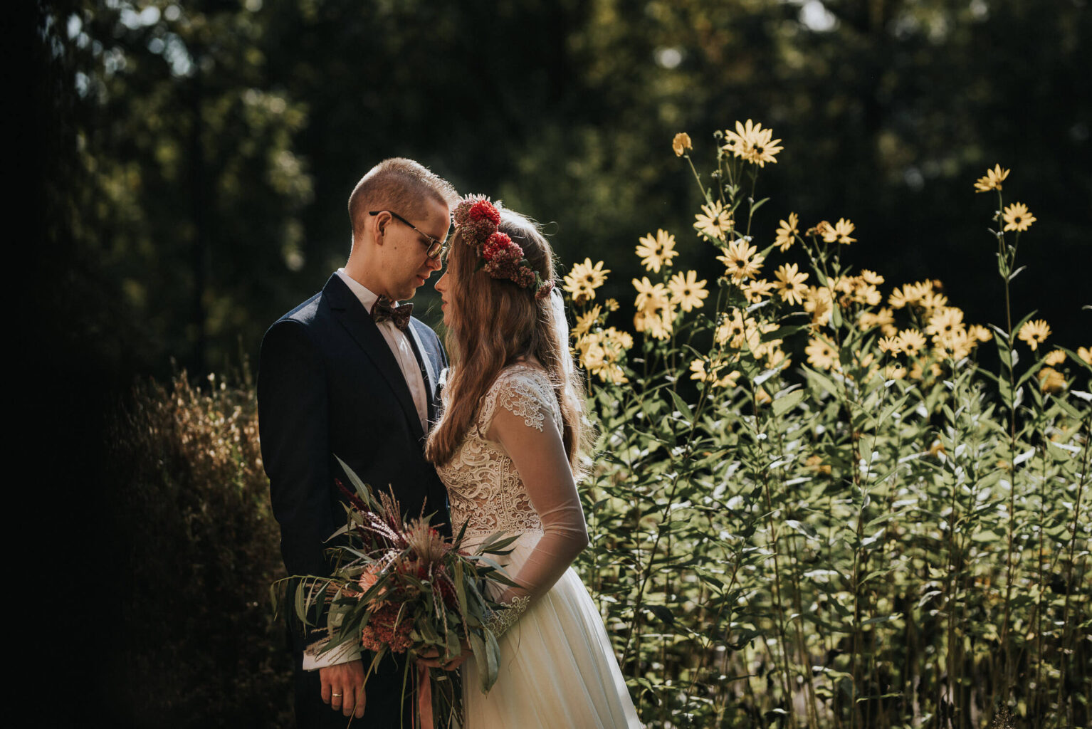 Para młoda pozuje na tle kwiatów w skansenie w Opolu