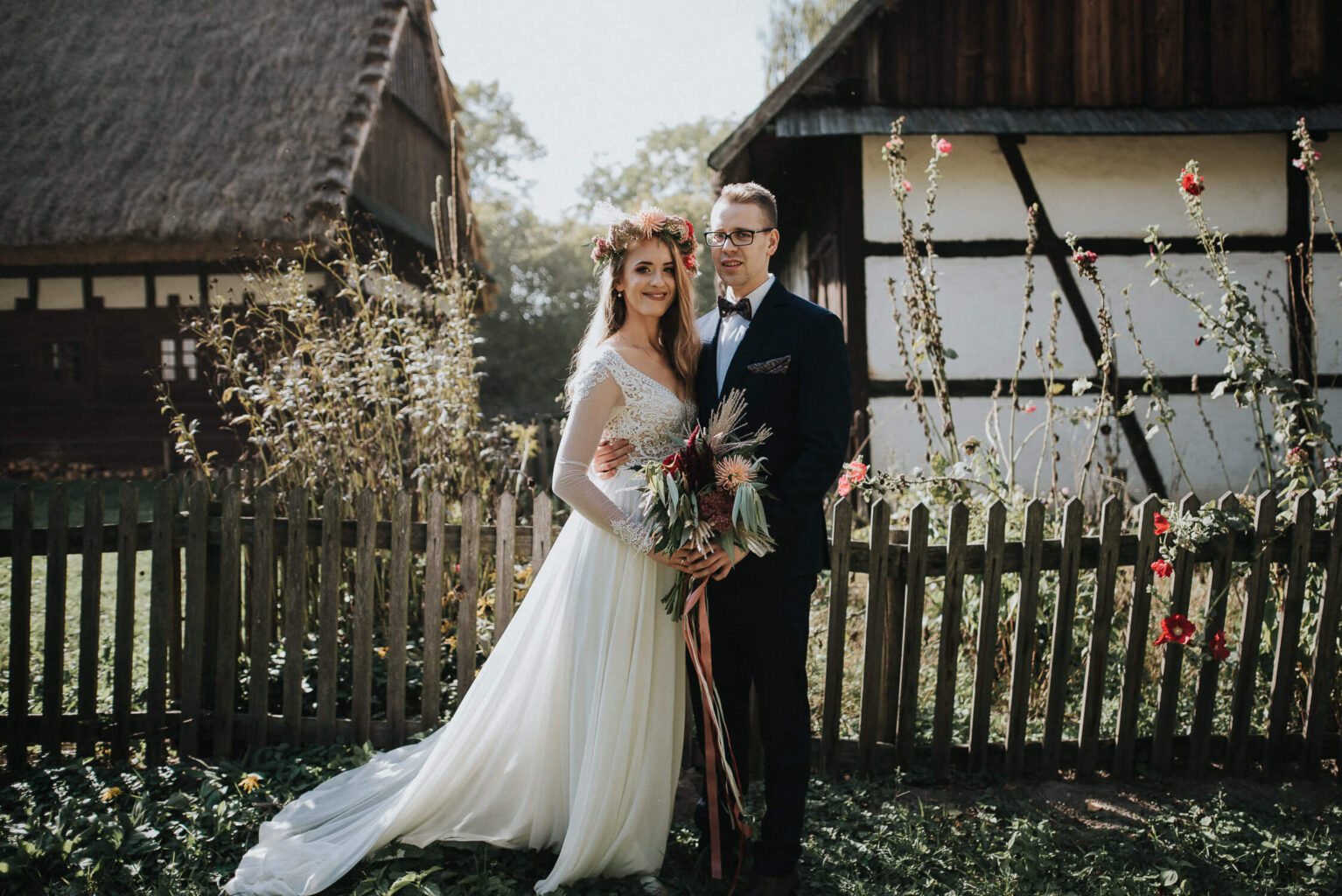 Rustykalna para młoda pozuje na tle płotku w skansenie w Opolu