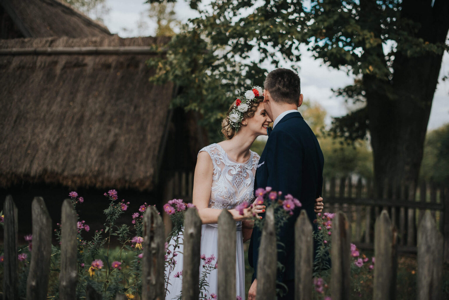 Przytulona para młoda za płotkiem w ogrodzie skansenu w Opolu