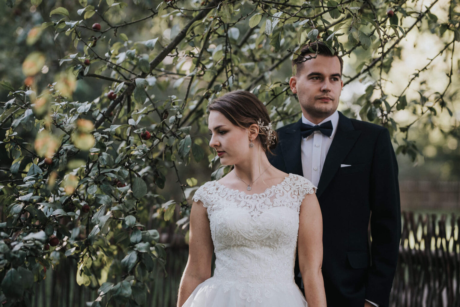 Para młoda pozuje na tle jabłoni w skansenie w Opolu podczas rustykalnej sesji zdjęciowej
