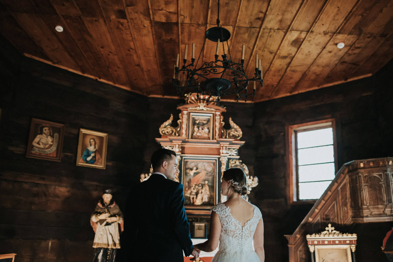 Para młoda we wnętrzu rustykalnego kościoła w Muzeum Wsi Opolskiej.